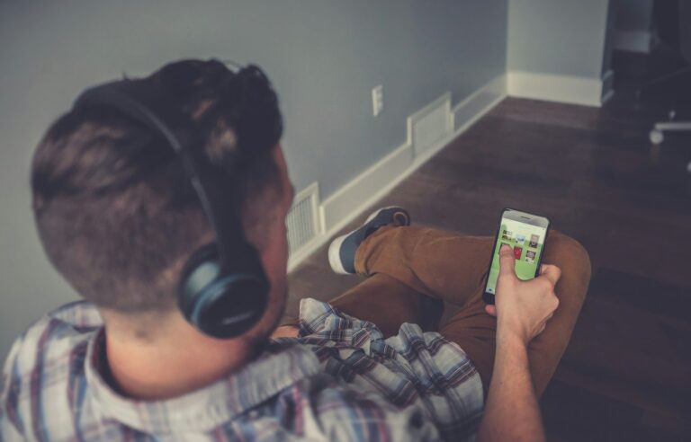 A person using a smartphone with headphones